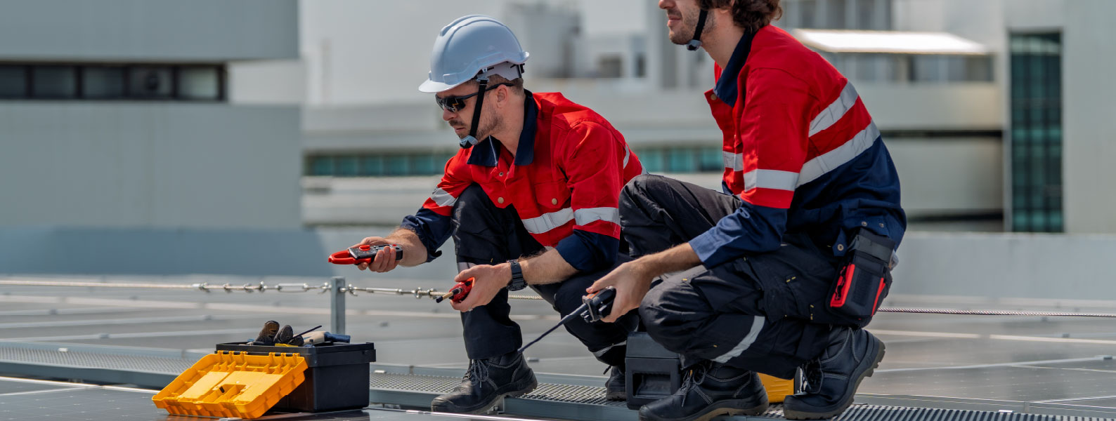 Two workers in FR clothing working on cables