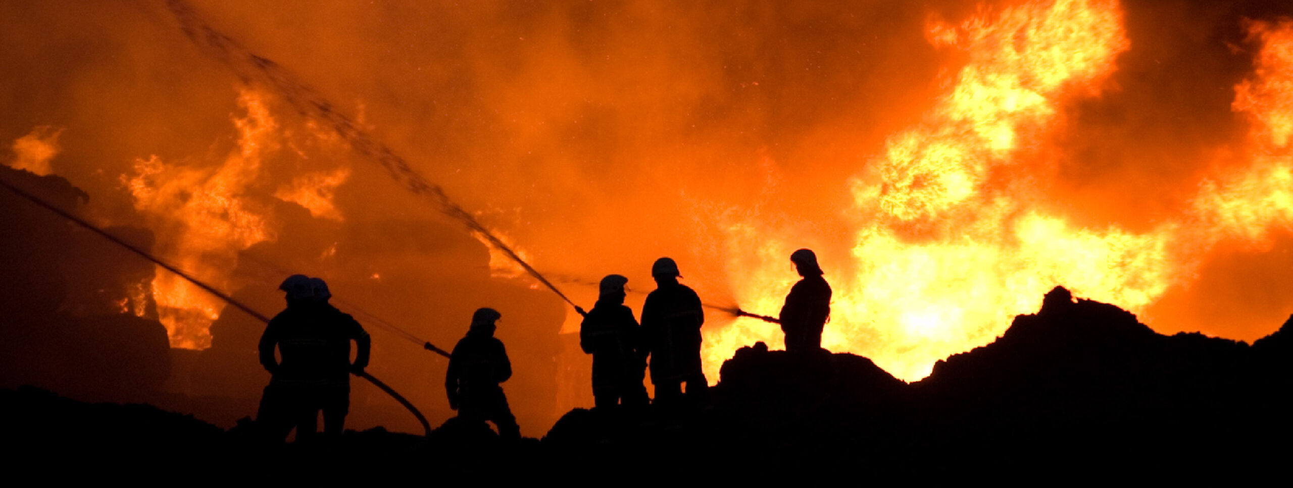 Firemen putting out large fire at night